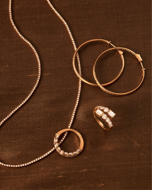 Gold jewelry set on brown fabric.