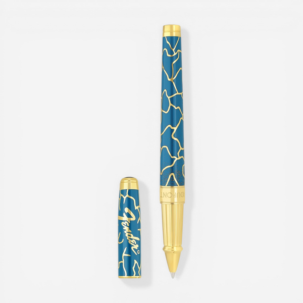 THE SOLIST S.T. Dupont x Fender blue and gold brass rollerball pen with intricate pattern.